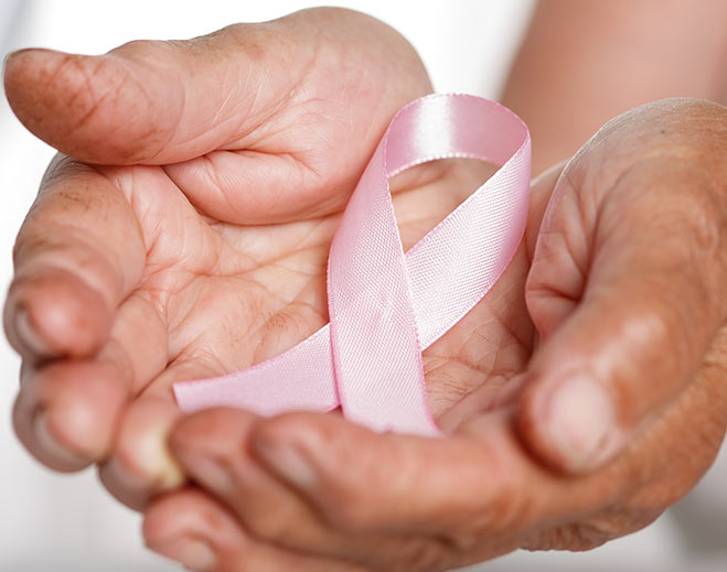 Hands holding pink breast cancer ribbon