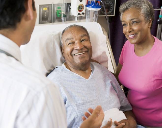 Doctor speaking with patient in hospital bed
