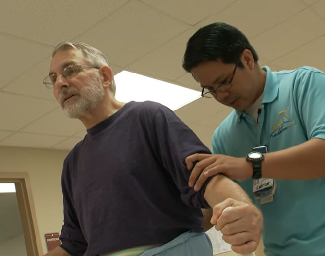 Therapy assistant supporting individual during walking exercise