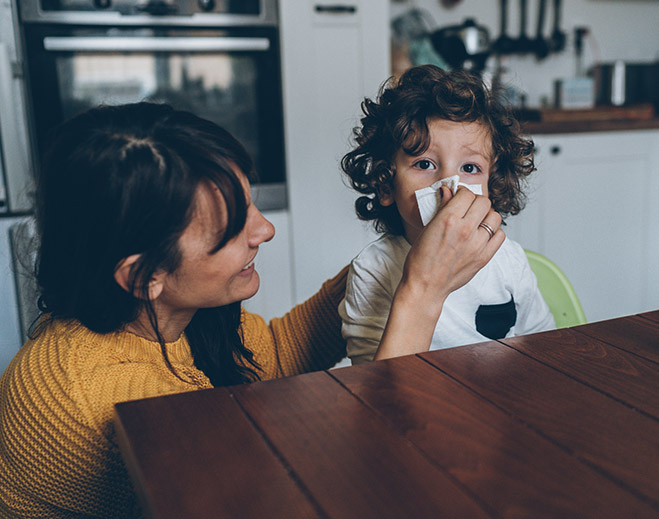 Adult supporting child at kitchen table