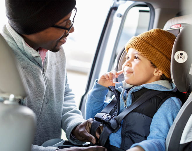 Niño asegurado en asiento de automóvil