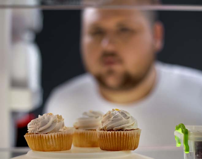 Persona observando postres en refrigerador