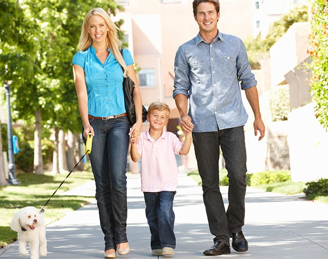 Familia caminando con mascota al aire libre