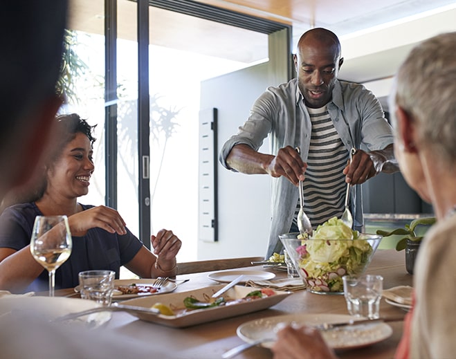Personas sirviendo ensalada durante la comida