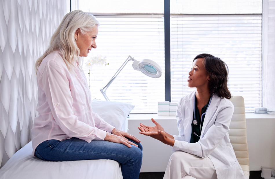 A doctor holds a tablet computer and discusses medical care options with a patient