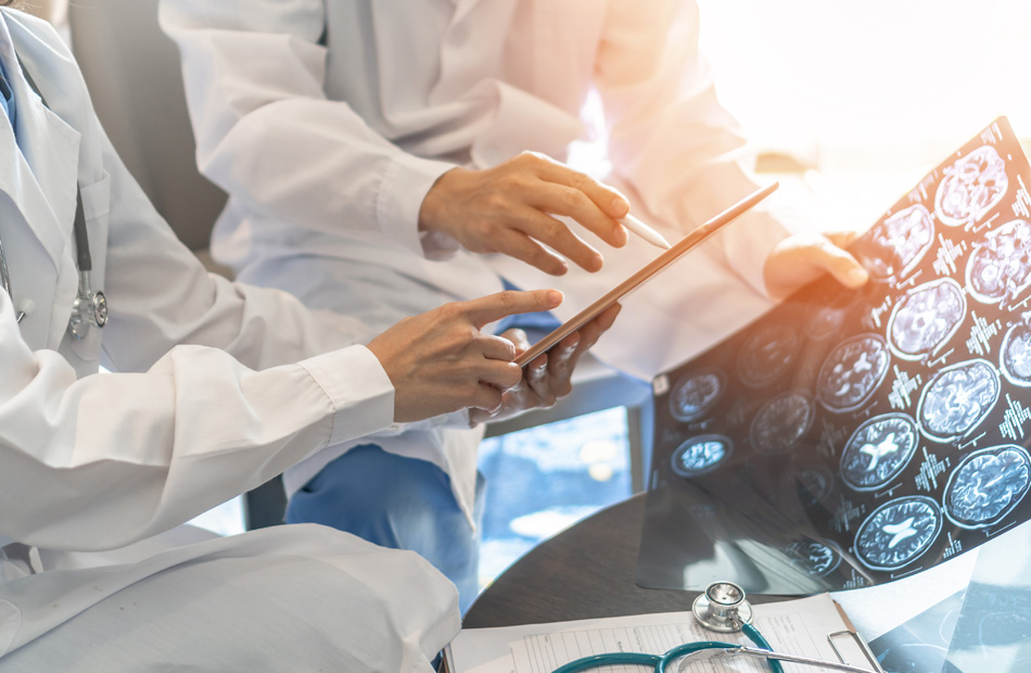 A doctor holds a tablet computer and discusses medical care options with a patient