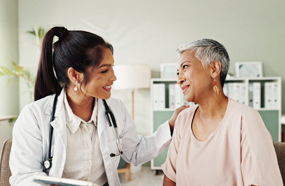 A doctor holds a tablet computer and discusses medical care options with a patient