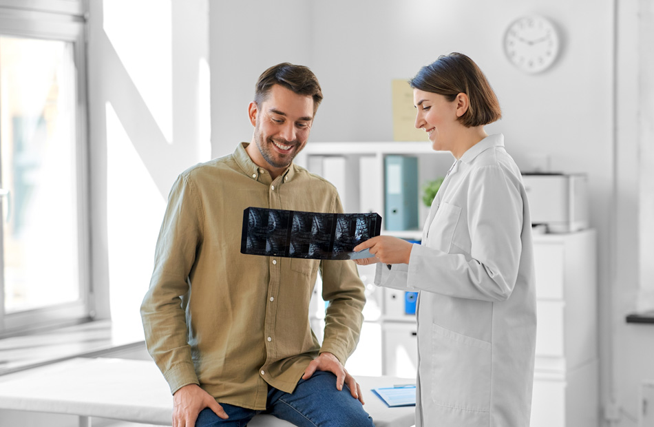 A doctor holds a tablet computer and discusses medical care options with a patient