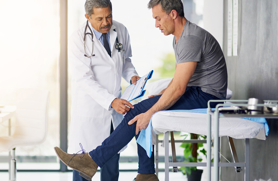 A doctor holds a tablet computer and discusses medical care options with a patient