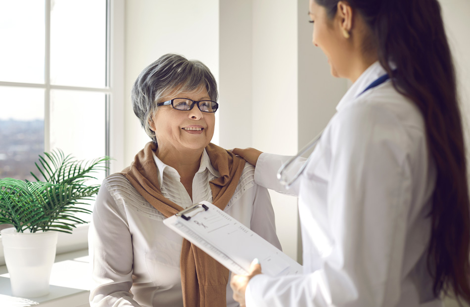 A doctor holds a tablet computer and discusses medical care options with a patient