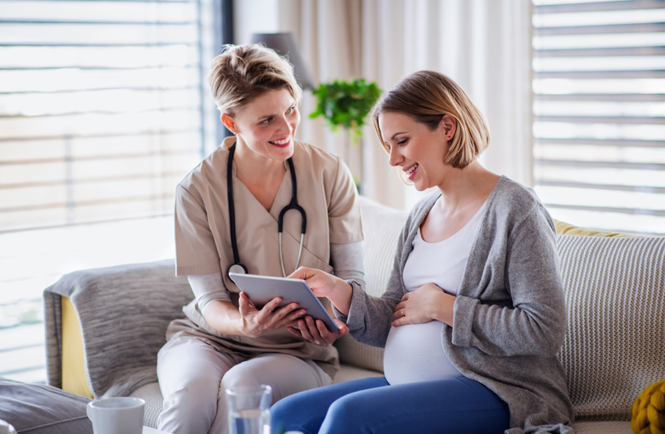 A doctor holds a tablet computer and discusses medical care options with a patient