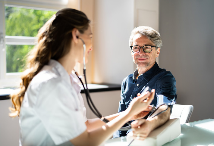 Healthcare provider checking patient’s blood pressure