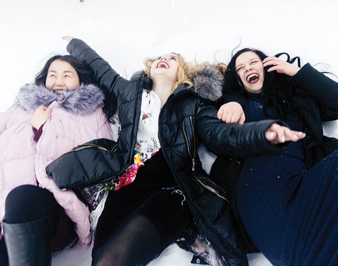 comunidad-familia-tres-mujeres-jugando-nieve